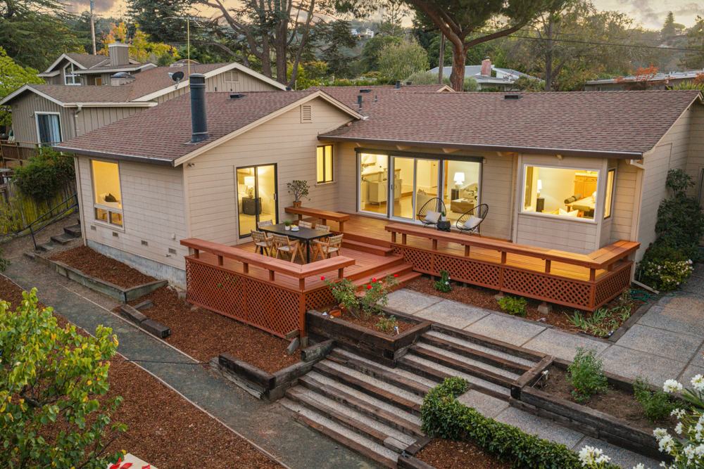 Aerial view of 251 Dedalera Drive at dusk, with the deck, the terraced garden steps and lit windows